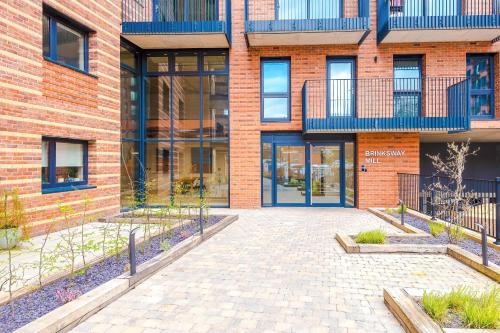 a brick building with a courtyard in front of it at Hilltop Serviced Apartments-Stockport in Stockport
