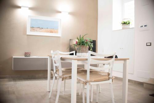 mesa de comedor blanca con 4 sillas blancas en Casa Al Vicoletto, en Módica