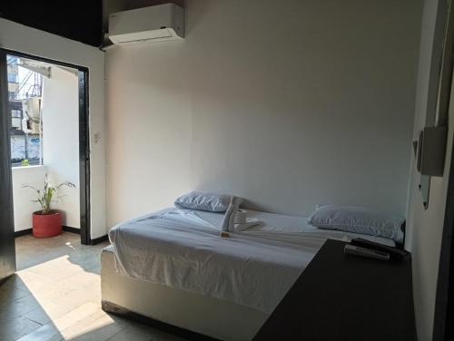 ein Schlafzimmer mit einem Bett in einem Zimmer mit Fenster in der Unterkunft Hotel La Séptima in Neiva