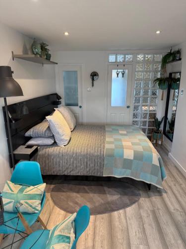 a bedroom with a large bed and a blue chair at Studio Tavros in Bristol