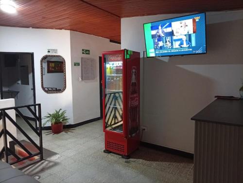 Ein Coca-Cola-Automat mit einem Fernseher an der Wand in der Unterkunft Hotel La Séptima in Neiva