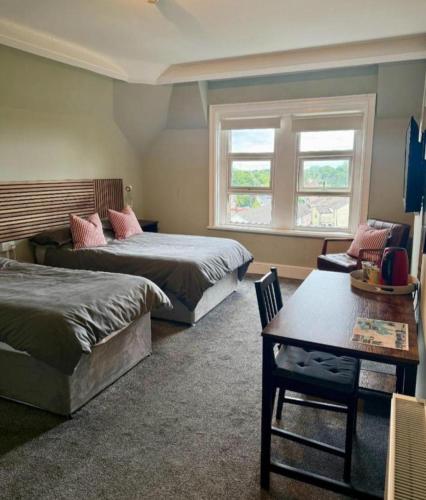 a bedroom with two beds and a table and a window at THE YoRK in Morecambe