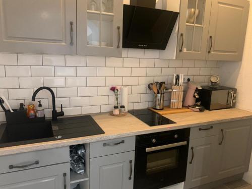 a kitchen counter with a sink and a microwave at Kurvilla Apartments in Landstuhl