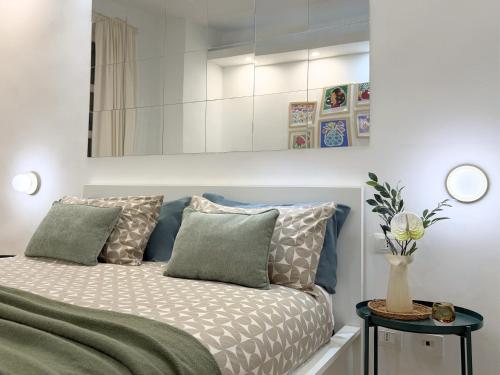 a bedroom with a bed with pillows and a mirror at Dimora dei Mercanti Suites - New Premium Rooms in Turin
