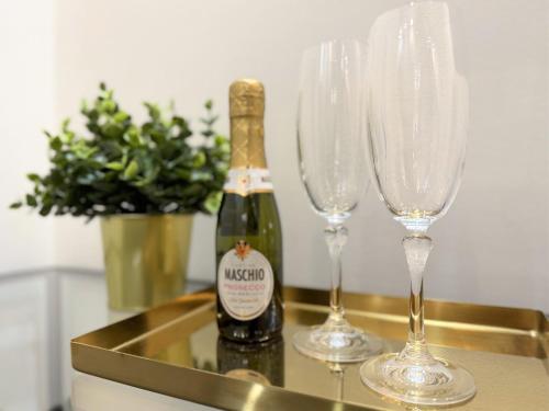 a bottle of champagne and two wine glasses on a tray at Dimora dei Mercanti Suites - New Premium Rooms in Turin
