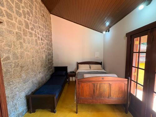a room with two beds and a bench in it at Refúgio Carangola in Petrópolis