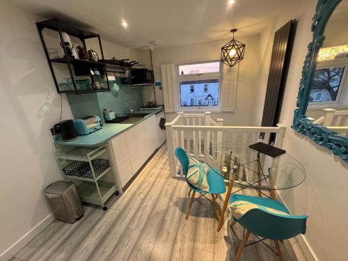 a kitchen with blue chairs and a table and a counter at Studio Tavros in Bristol