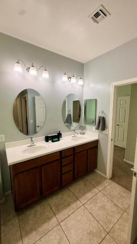 a bathroom with two sinks and two mirrors at 4bed 2bath Retreat - 120inch Theater in Corona de Tucson