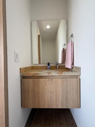 a bathroom with a sink and a mirror at Modern Apartment With Espectacular Panoramic Views in Pereira