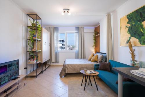 a living room with a bed and a blue couch at ILIRIA Apartment in Durrës