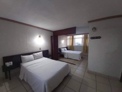 a hotel room with two beds and a window at Hotel Estación Guadalajara in Guadalajara