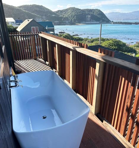 a bath tub on a balcony with a view of the ocean at Epic Ocean Views & Outdoor bath in Wellington