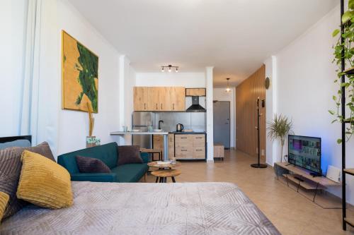 a living room with a blue couch and a kitchen at ILIRIA Apartment in Durrës