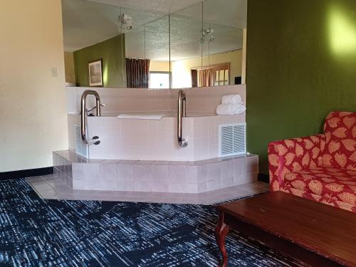 a bathroom with a tub with a mirror and a couch at Quality Inn Conference Center Logansport in Logansport