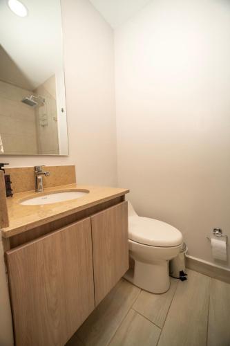 a bathroom with a toilet and a sink and a mirror at Refugio Del Mar Bello Horizonte Playa Dormida in Santa Marta