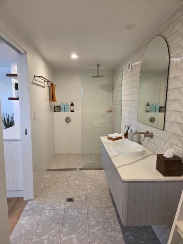 a bathroom with a sink and a mirror at Seaclusion at Byron in Byron Bay