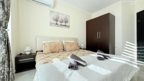 a bedroom with a large bed with white sheets at Atlantis Resort Nikol in Burgas