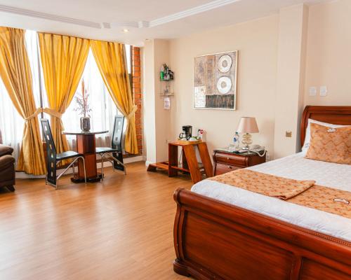 a bedroom with a bed and a table and chairs at Kuna Hotel in Cuenca