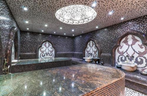 a large bathroom with a tub and a chandelier at Atlantis Resort Nikol in Burgas
