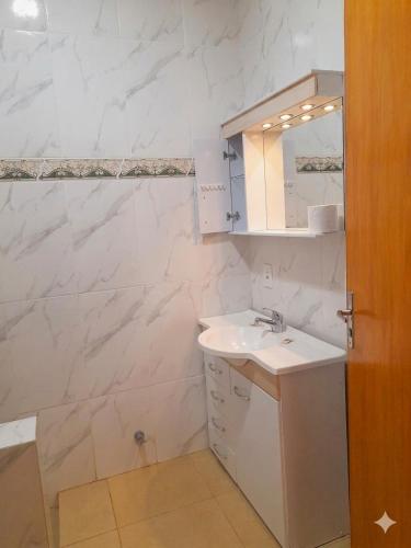 a white bathroom with a sink and a mirror at Resort Sport in Independencia