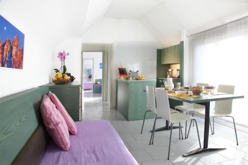 米蘭的住宿－朱斯蒂6住宅酒店，厨房以及带桌椅的起居室。