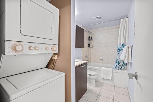 a white bathroom with a sink and a toilet at Stylish 2BR Downtown Sanctuary - Free Parking in Toronto