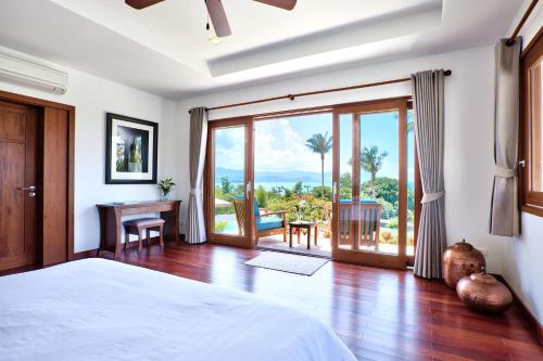 a bedroom with a bed and a sliding glass door at Baan Apsara - Stunning Sea View 3 Bed Pool Villa in Choeng Mon Beach