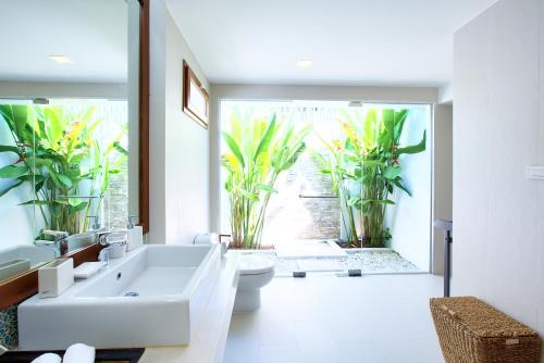 a bathroom with a sink and a toilet and a mirror at Baan Apsara - Stunning Sea View 3 Bed Pool Villa in Choeng Mon Beach