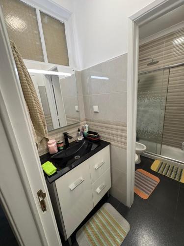 a bathroom with a sink and a toilet and a mirror at Quarto Espaçoso in Amora