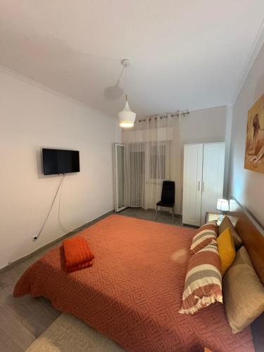 a bedroom with a bed and a flat screen tv at Quarto Espaçoso in Amora