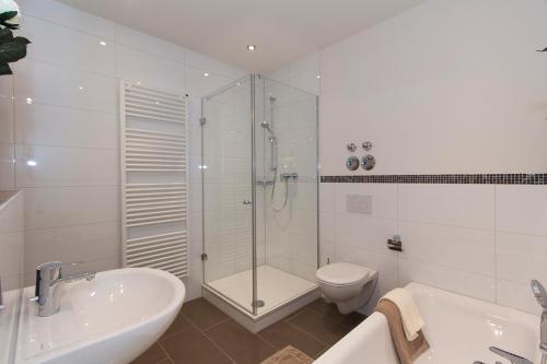 ein Bad mit einer Dusche, einem WC und einem Waschbecken in der Unterkunft Gästehaus am Lindenhain in Erding