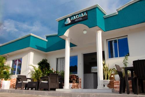a restaurant with a blue and white building at Hotel ALCALA in Mingueo