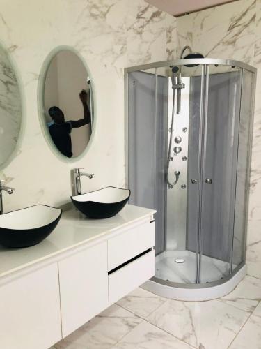 a bathroom with two sinks and a shower at chez Louise in Saly Portudal