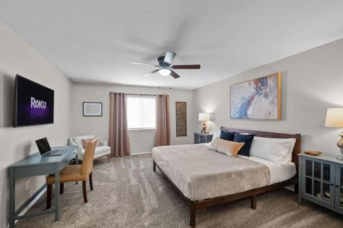 a bedroom with a bed and a desk with a laptop at Modern Home Close to It All in DFW Texas! in Grand Prairie