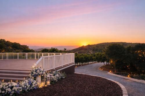 a sunset from the deck of a house with flowers at Panorama Paradiso by CasadeLuz, 5Acre 360 Retreat close to Old Town Temecula Wine Country in Temecula