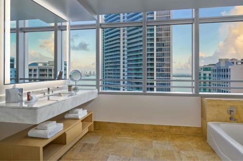 a bathroom with two sinks and a large window at Brickell Arch, a Luxury Collection Hotel, Miami in Miami