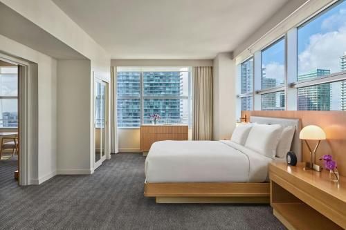 a hotel room with a bed and large windows at Brickell Arch, a Luxury Collection Hotel, Miami in Miami