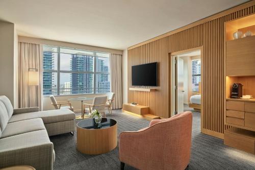 a living room with a couch and a room with a tv at Brickell Arch, a Luxury Collection Hotel, Miami in Miami
