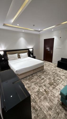 a bedroom with a large bed in a room at شقق تبيان سويت للشقق المخدومة الفرع الاول in Ar Ruwanah