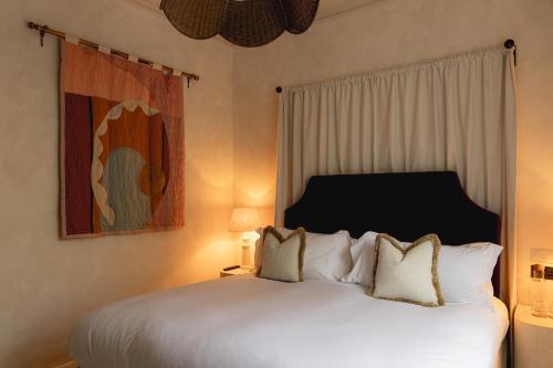 a bedroom with a large white bed with two pillows at No 15 by GuestHouse, Bath in Bath