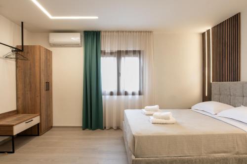 a bedroom with a bed with towels on it at Nouvelles Roses 1 in Nea Roda