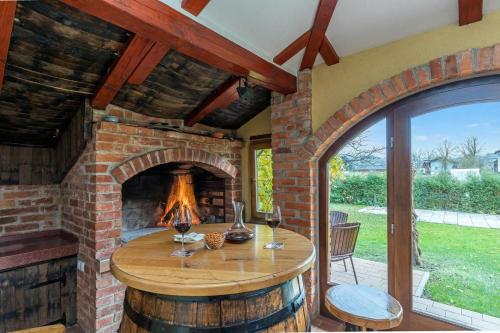 a room with a brick fireplace and a table with wine glasses at Forge of Happiness Rustic Retreat - Happy Rentals in Gradac
