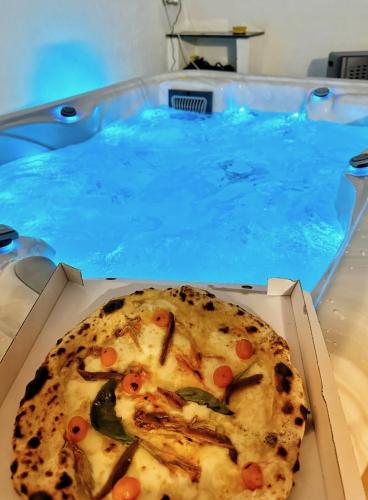 a pizza in a box in front of a swimming pool at Qatar Apartment in Cosenza