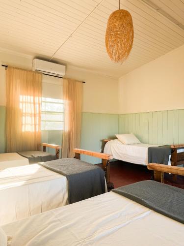 a room with three beds and a chandelier at Casa Cosmos in Colonia Ayui