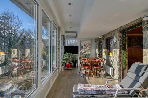 a conservatory with a table and chairs and a large window at Forest Retreat Bonidesa - Terrace & Jacuzzi - Happy Rentals in Ljubno