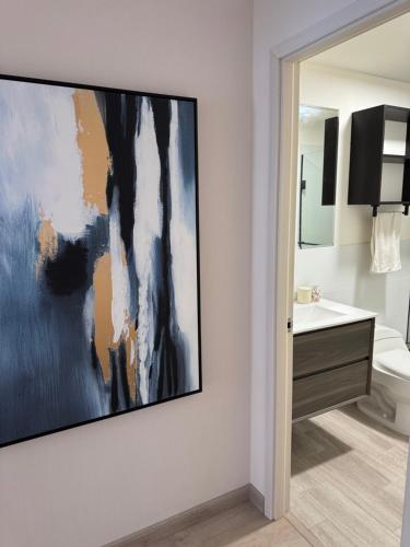 a painting hanging on a wall in a bathroom at Miraflores Loft Piscina in Lima