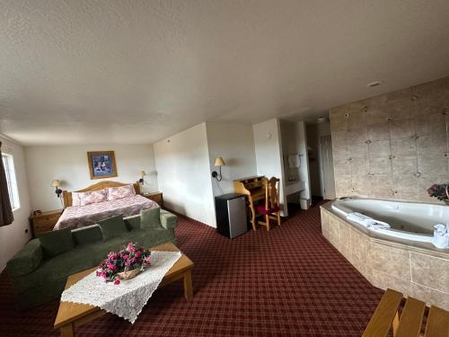 a hotel room with a bed and a bath tub at Columbine Inn and Suites in Leadville