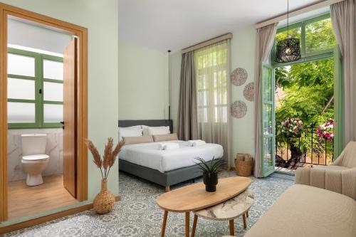 a bedroom with a bed and a couch and a table at Aurelia Boutique - Suites in Rhodes Town