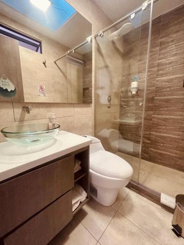 a bathroom with a sink and a toilet and a shower at Agora Suites Hotel, Check-in digital fácil con atención virtual 24h in Bogotá