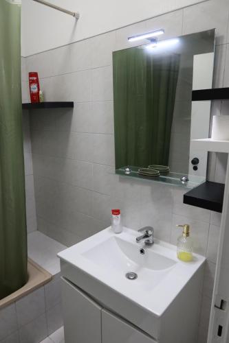 a bathroom with a sink and a mirror and a shower at Apart Lisbon Airport in Lisbon